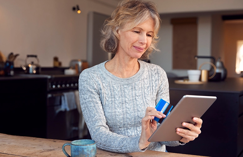 woman on tablet with debit card